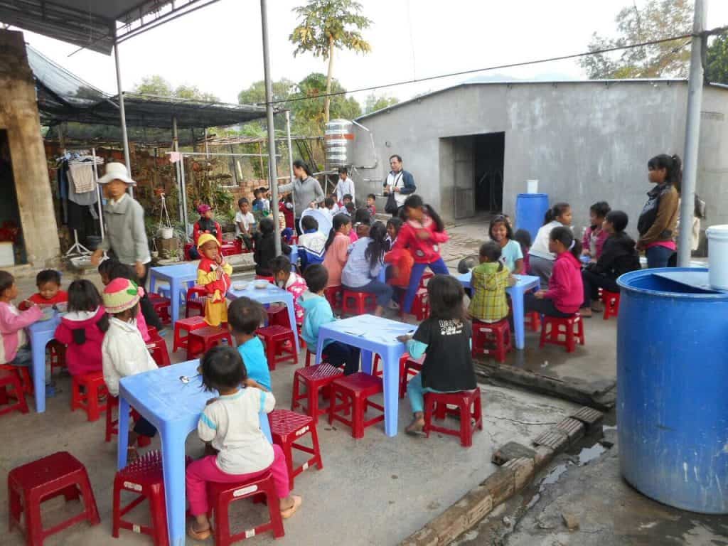 Children eating breakfast with nuns before school
