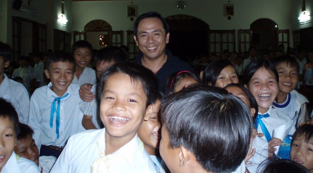 Picture showing Father Hieu with children laughing